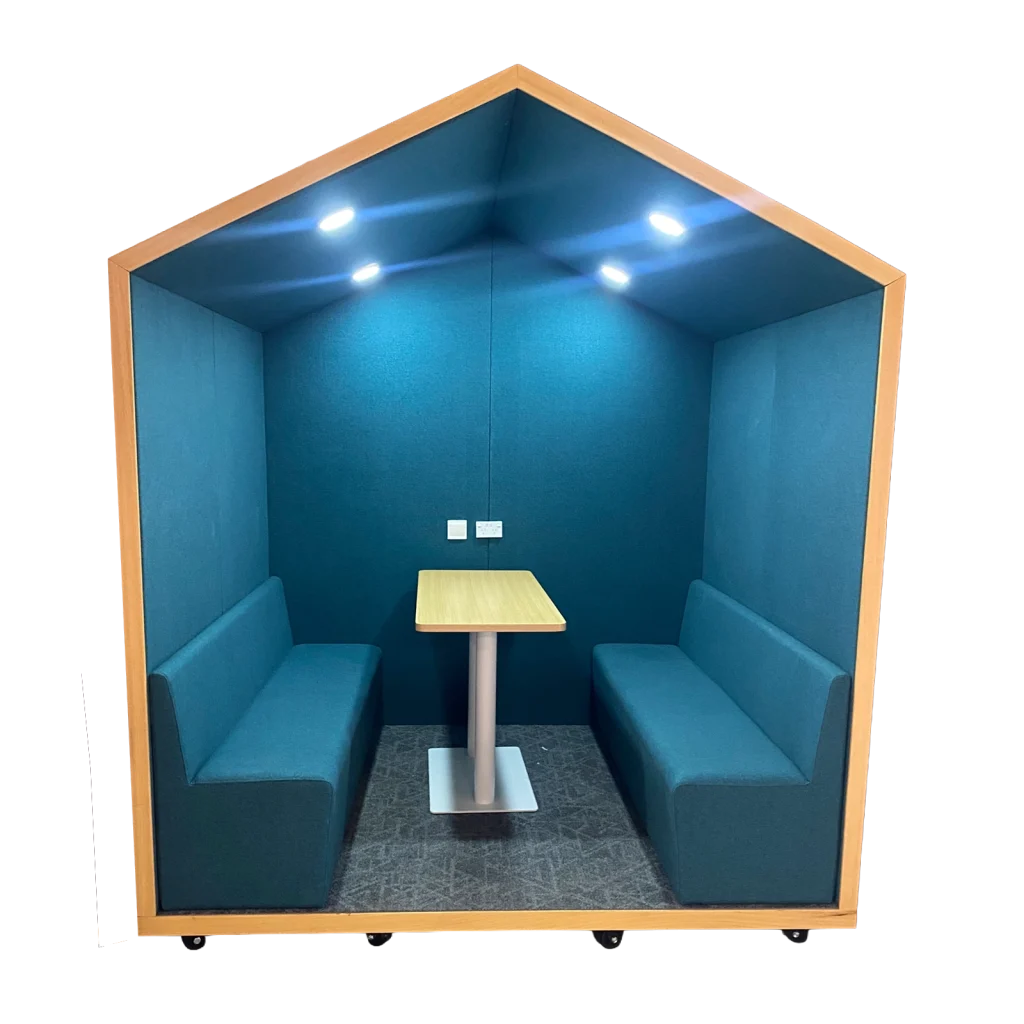 Teal upholstered booth in a private pod with a light wooden rectangular table and ceiling spotlights above.